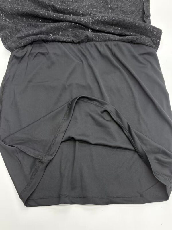 Close-up of a black athletic skirt made from lightweight, breathable fabric, designed for sports or casual wear, with a comfortable elastic waistband.