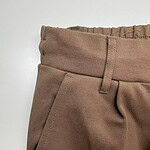 Close-up of brown casual women's pants with elastic waistband and front pocket, suitable for everyday wear and fashion.