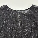 Close-up of a black dress adorned with intricate beadwork, perfect for formal occasions and evening wear.