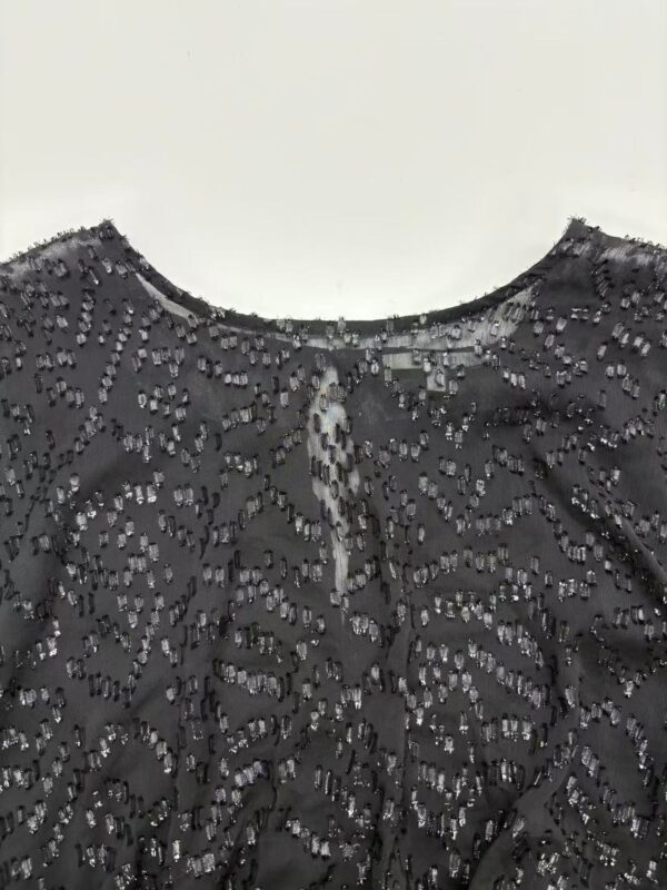 Close-up of a black dress adorned with intricate beadwork, perfect for formal occasions and evening wear.