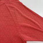 Close-up of a red men's sports jersey with textured pattern, ideal for athletic wear and active lifestyle.