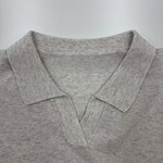 Close-up of a light grey polo shirt with a V-neck collar, made from soft cotton fabric, suitable for casual and everyday wear.