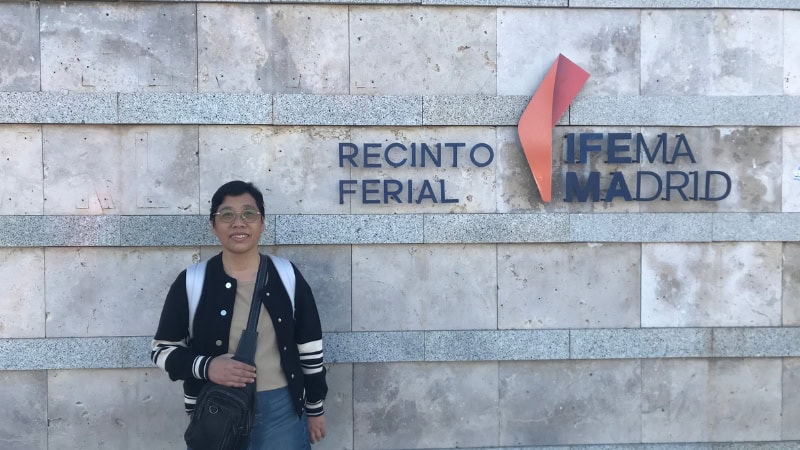 Person standing in front of Recinto Ferial Madrid sign at the exhibition center, wearing casual clothing and glasses.